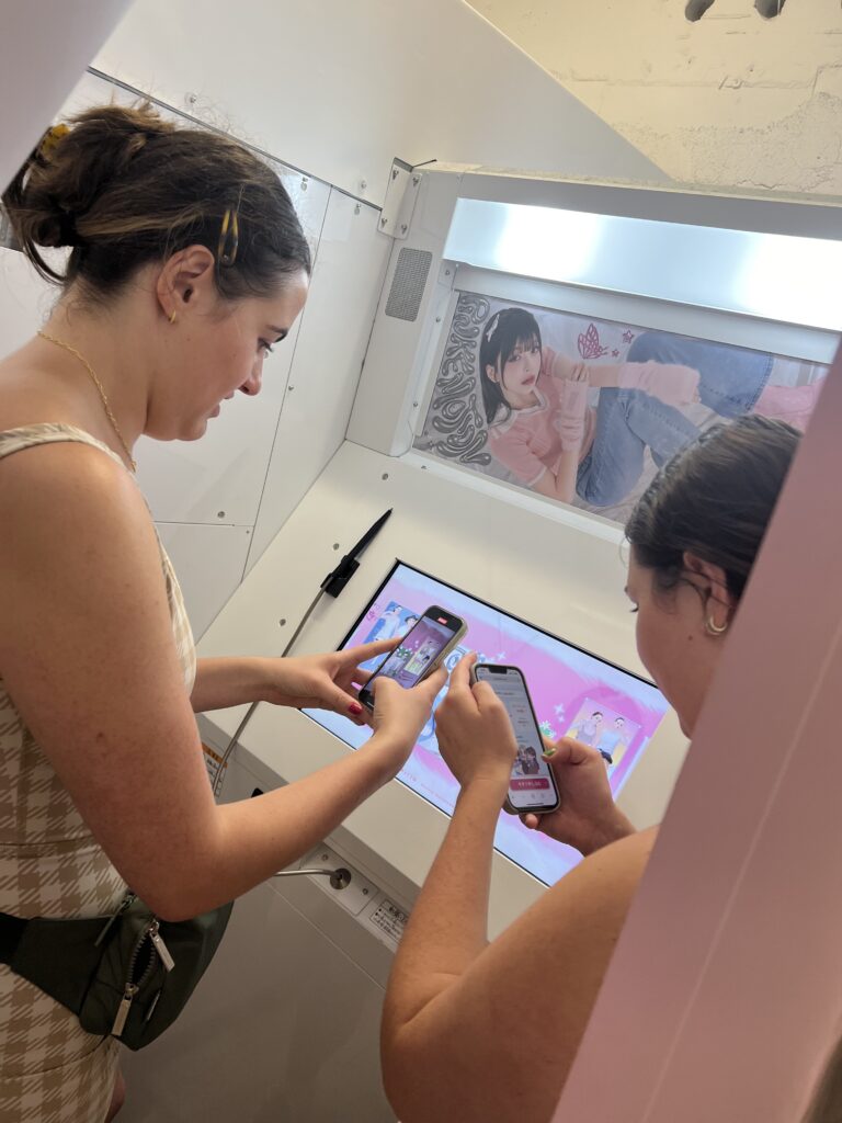 young women taking photos in a Japanese photo booth in Harajuku Tokyo