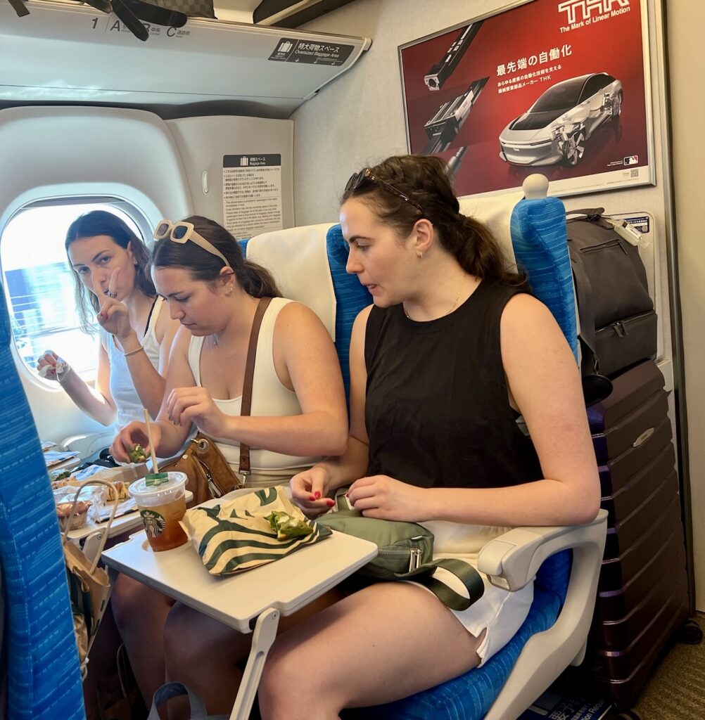 Adult daughters eating ekiben on the shinkansen bullet train between cities on a 10-day Japan itinerary
