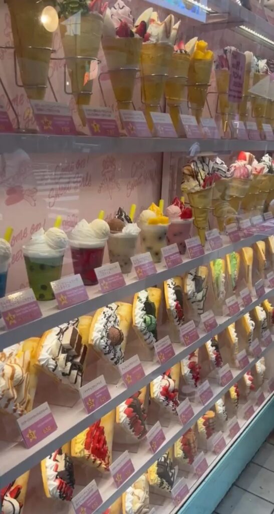 Rows of elaborately decorated Harajuku crepes displayed on shelves at a crepe shop on Takeshita Street Tokyo Japan