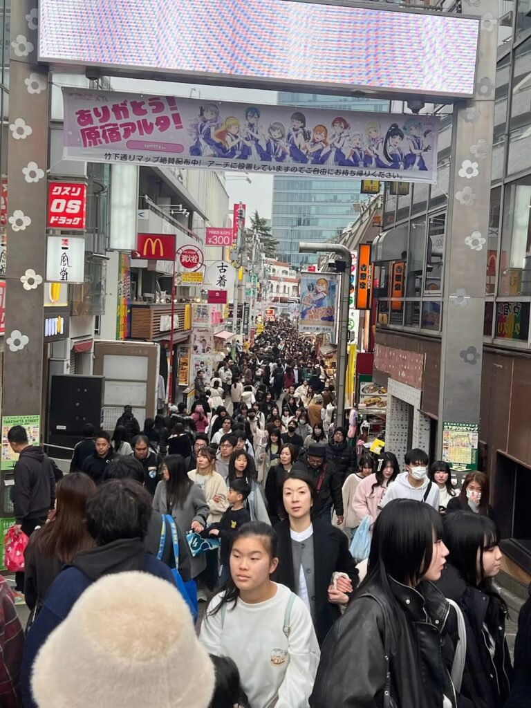 Crowds of people walking through Takeshita Street in Harajuku Tokyo Japan