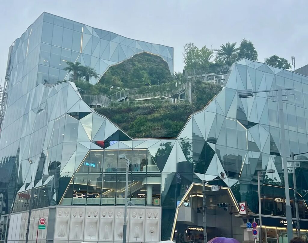 Geometric mirrored glass facade of Tokyu Plaza Omotesando Harajuku shopping complex in Tokyo Japan