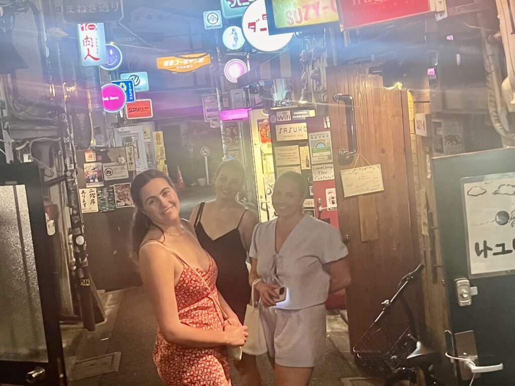 Family walking through the narrow alleys of Golden Gai in Shinjuku at night